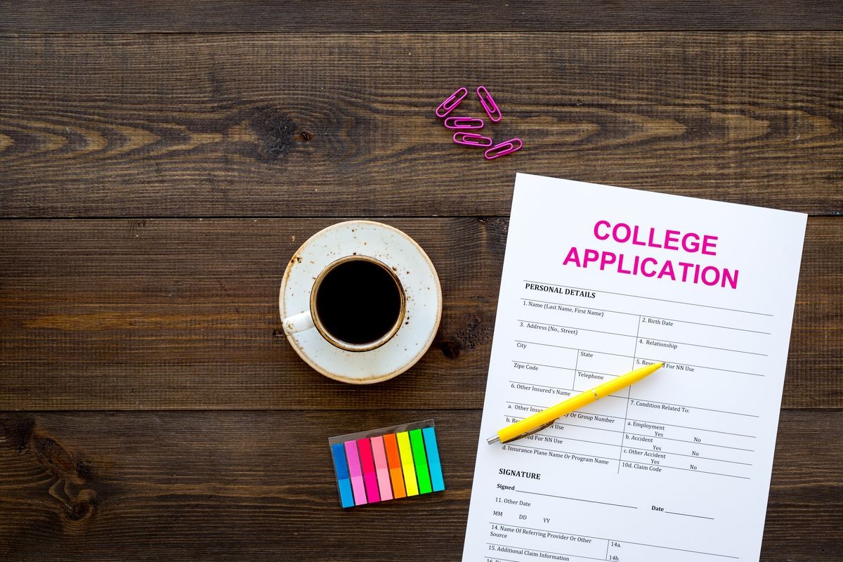 Apply college. Empty college application form near coffee cup and stationery on dark wooden background top view copy space